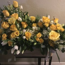 Large yellow rose arrangement with white flowers and greenery