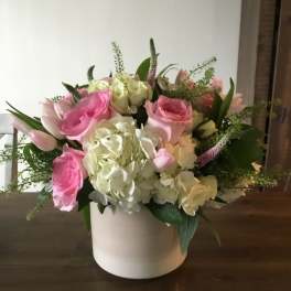 Pink and white roses with hydrangeas in a white vase