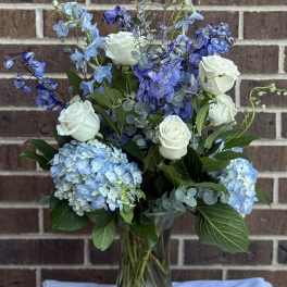 Blue and white floral arrangement in a glass vase
