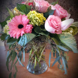 Pink roses and a gerbera daisy in a glass vase