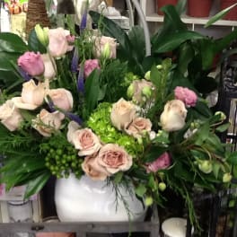 Pink and cream roses arranged in a white vase