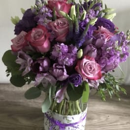 Bouquet of pink and purple flowers in a patterned box