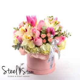 Pink and cream bouquet with roses, tulips, orchids, and hydrangeas in a pink hat box