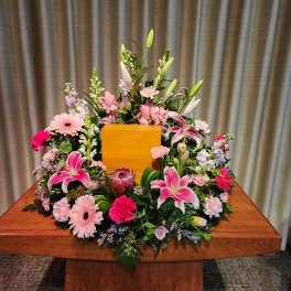 Large pink and white floral arrangement on a wooden table