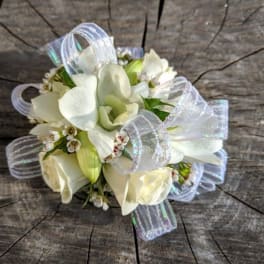 White floral wrist corsage with sheer ribbon loops