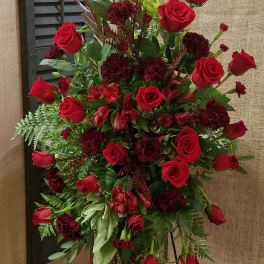 Tall red rose and burgundy floral standing arrangement on an easel