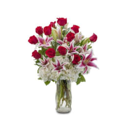 Red roses and pink lilies in a clear glass vase