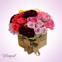 Round bouquet of pink, red, and lavender roses in a burlap-wrapped box