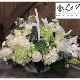 White floral arrangement in a low basket with lilies and roses
