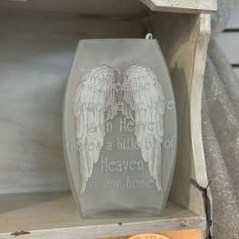 Gray coffin-shaped plaque with white angel wings and memorial text