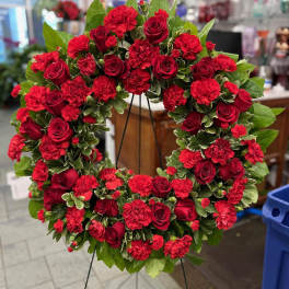 Red rose and carnation wreath on a stand