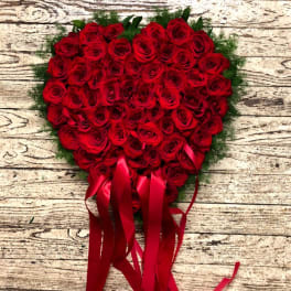 Heart-shaped bouquet of red roses with long red ribbons