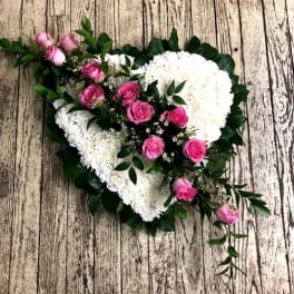 Heart-shaped floral arrangement with pink roses and white flowers