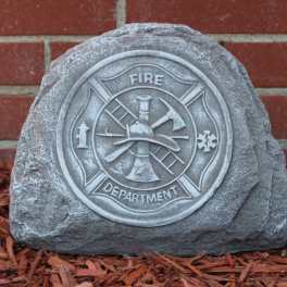 Fire department memorial stone in front of a brick wall
