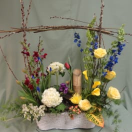 Mixed floral arrangement in a white rectangular container with tall branches