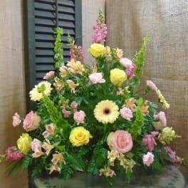 Mixed bouquet with yellow roses, pink carnations, and pale daisies