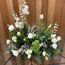 White floral arrangement with tulips and roses in a clear vase
