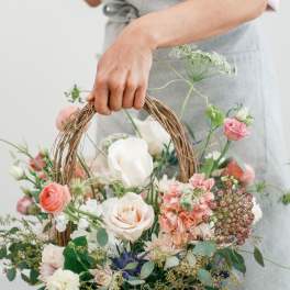 Basket of pastel flowers with roses and carnations