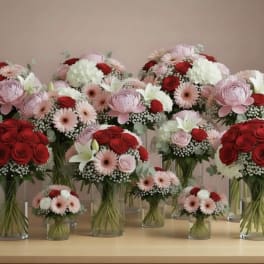 Assorted pink and red flower bouquets in clear glass vases