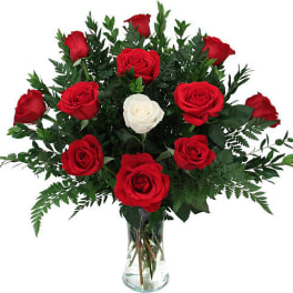 Red and white roses arranged in a clear glass vase