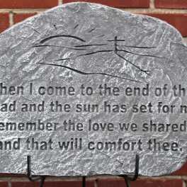 Engraved memorial stone with a quote on a brick wall