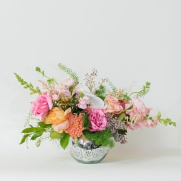 Mixed pink and peach flowers in a clear glass vase