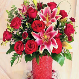 Bouquet of red roses and pink lilies in a red vase