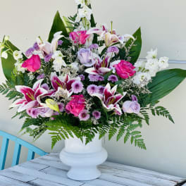 Large mixed bouquet in a white pedestal vase with pink and white flowers