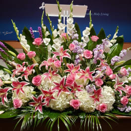 Large pink and white lily and rose arrangement with hydrangeas and lavender flowers in a low spray design