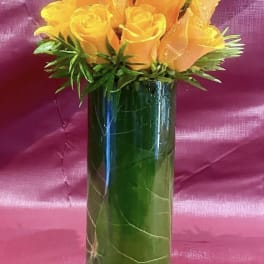 Orange roses arranged in a tall glass vase