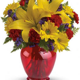 Bouquet of yellow lilies, daisies, and red flowers in a red vase