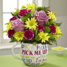 Pink roses and yellow daisies in a mug-shaped vase