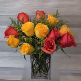 Bouquet of red and yellow roses in a clear glass vase