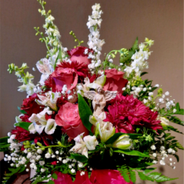 Pink and white mixed flower arrangement with a small angel figurine