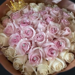 Round bouquet of pink and cream roses with crystal centers and a small gold crown on top