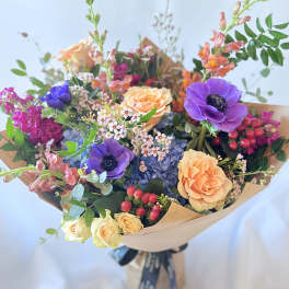 Mixed bouquet with purple anemones, peach roses, and blue hydrangea