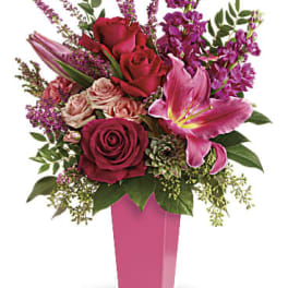 Pink and red bouquet with roses and a lily in a pink vase