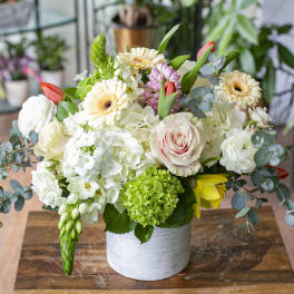 Mixed bouquet in a white vase with white, pink, and yellow blooms