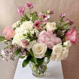 Pink and white flower arrangement in a clear glass vase