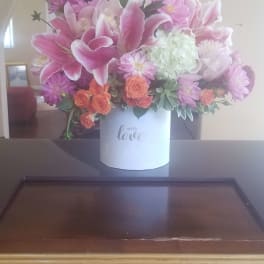 Pink lilies and mixed flowers in a white box vase
