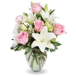 Pink roses and white lilies arranged in a clear glass vase