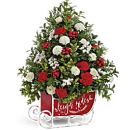 Red and white floral arrangement in a sleigh-shaped container