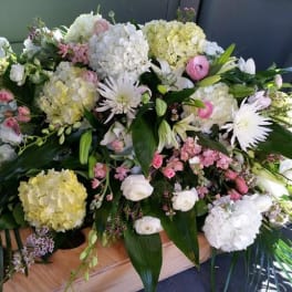Large white and pink floral casket spray with lilies and hydrangeas