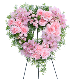 Heart-shaped pink floral wreath on a stand