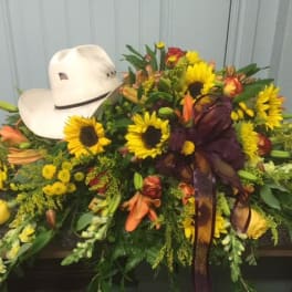 Cowboy hat resting on a large sunflower and mixed flower arrangement