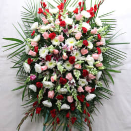 Large standing floral spray with pink, white, and red flowers