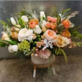 Mixed bouquet of peach, white, and coral flowers in a vase