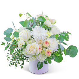 White roses and chrysanthemums in a white vase with green foliage