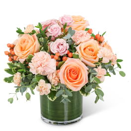 Peach and pink roses with carnations in a glass vase