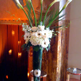 Tall white floral arrangement in a clear glass vase